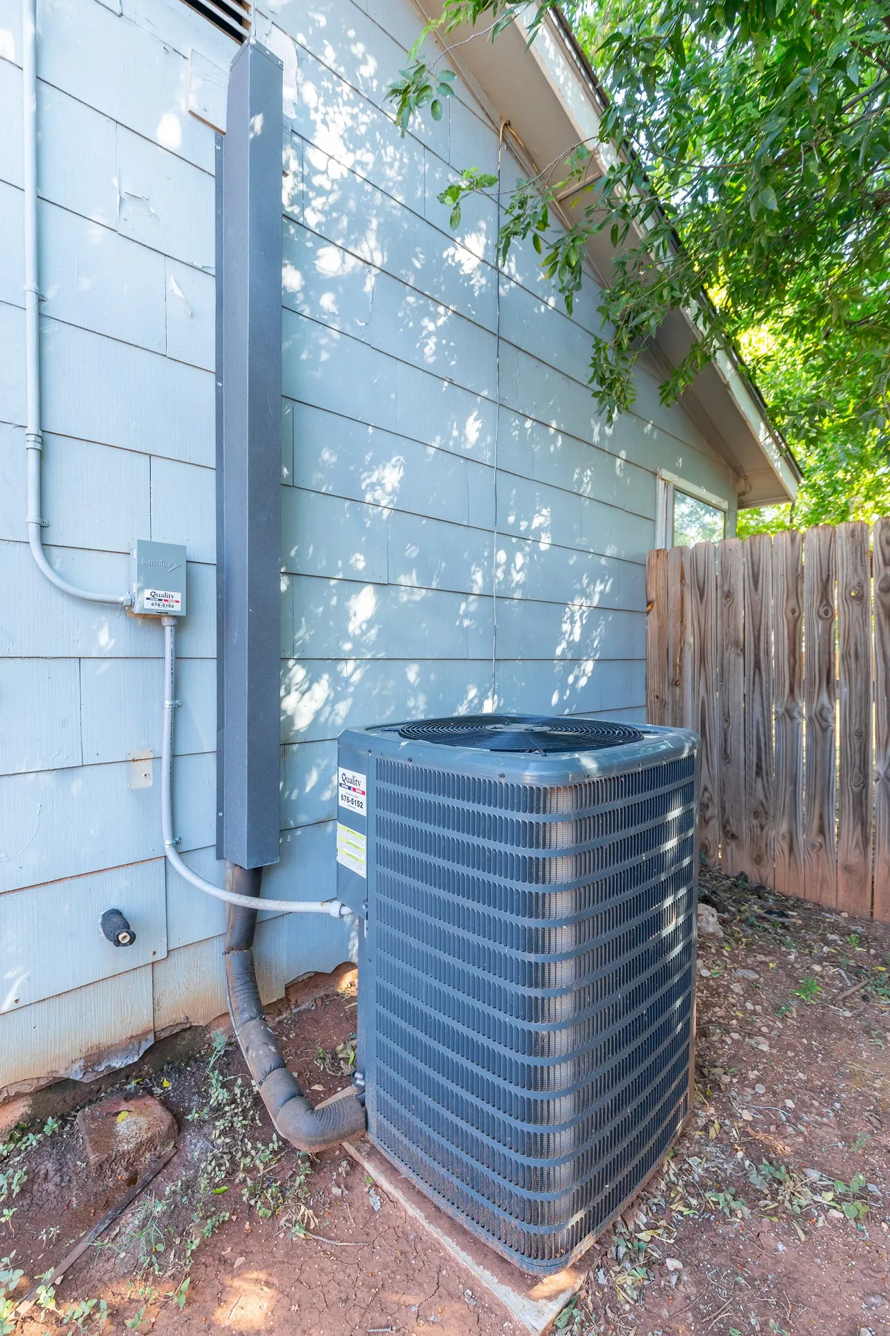 Exterior siding with a window and an outdoor HVAC unit on a concrete pad