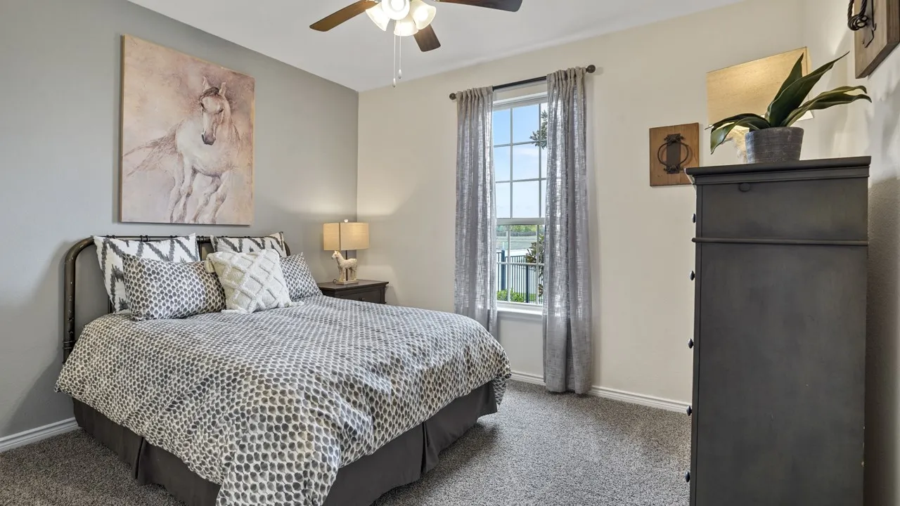 Recessed window with curtain rods, ceiling fan with light fixture, and wall-to-wall carpeting