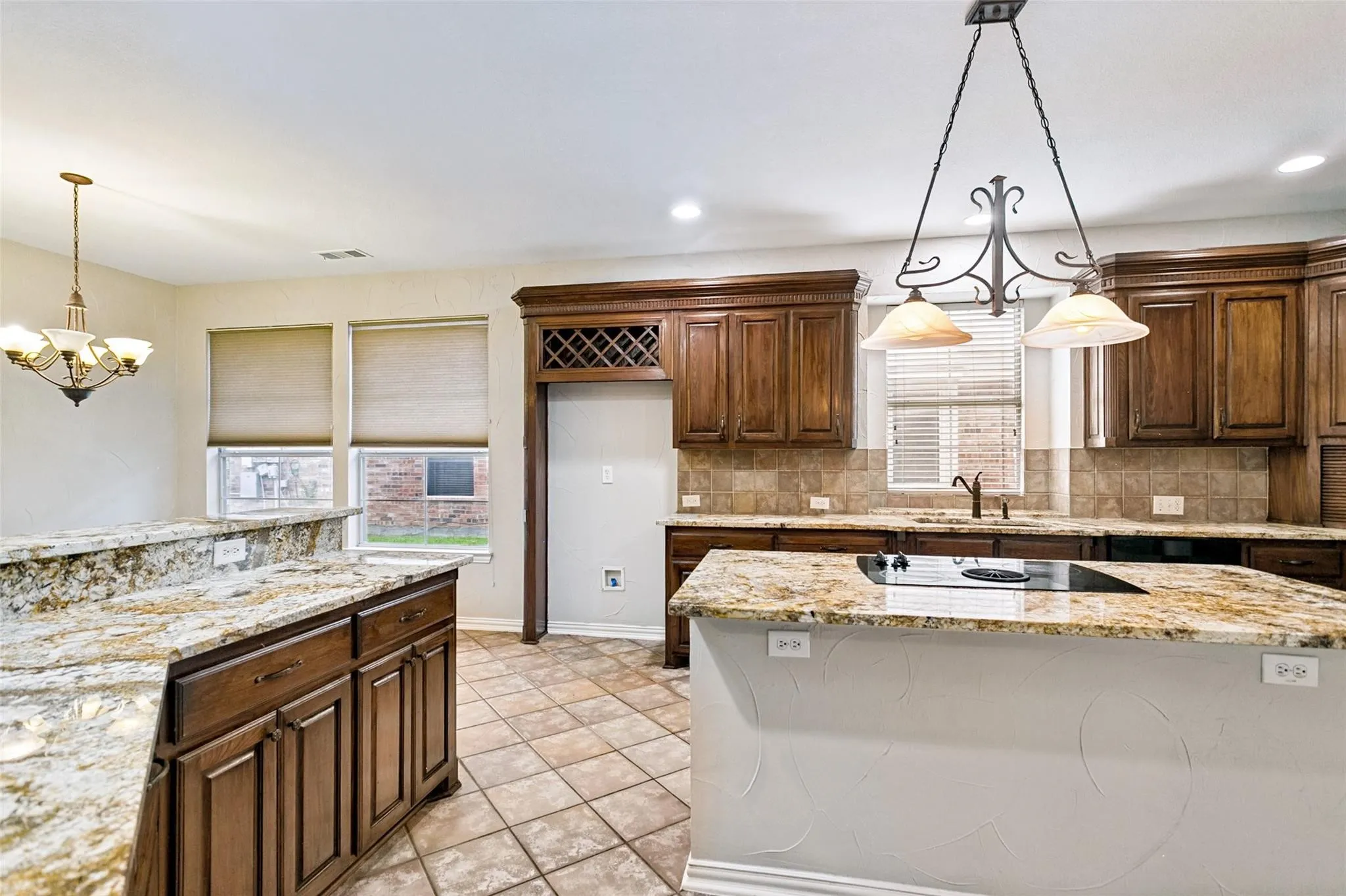 Kitchen featuring wood cabinetry, granite countertops, tile flooring, a tile backsplash, and a built-in wine rack