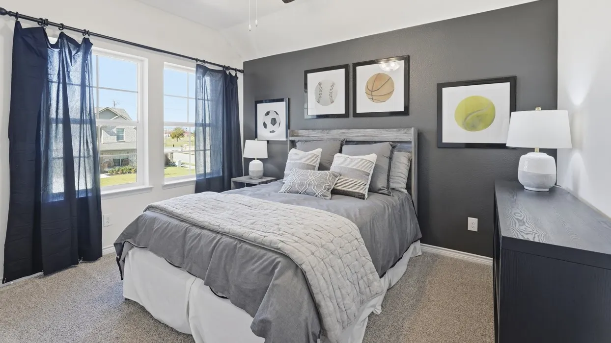 Two large windows, gray accent wall, neutral carpet flooring, and a ceiling fan