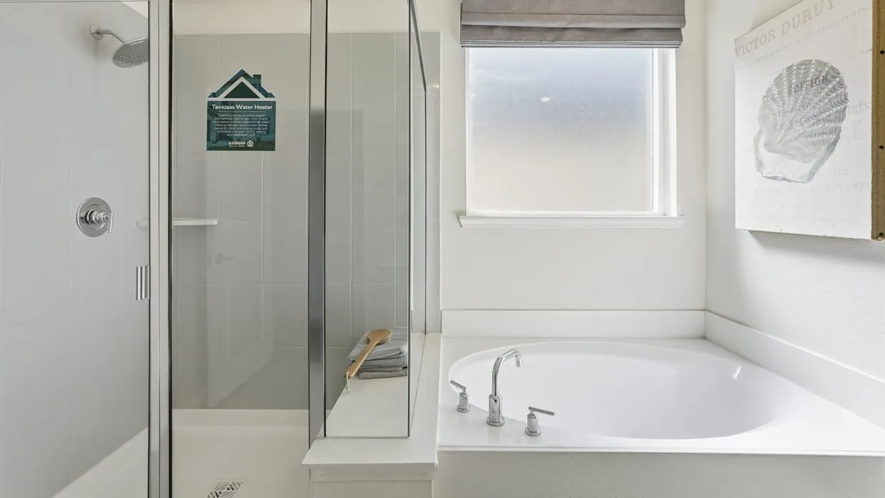 Enclosed shower with glass paneling, tile surround, and built-in shelving