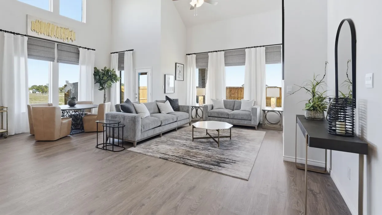 Vaulted ceilings with a ceiling fan, wood-finish flooring, and large windows with privacy blinds and drapery rods