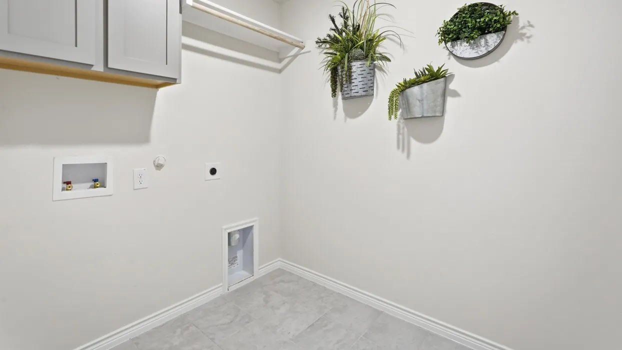 Laundry area featuring upper cabinetry, a hanging rod, and tile flooring