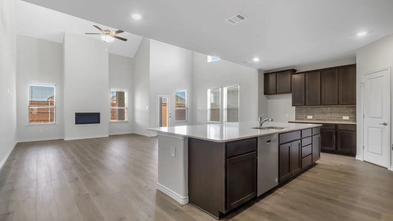 Open-concept living space with vaulted ceilings, wood-finish flooring, and an electric fireplace
