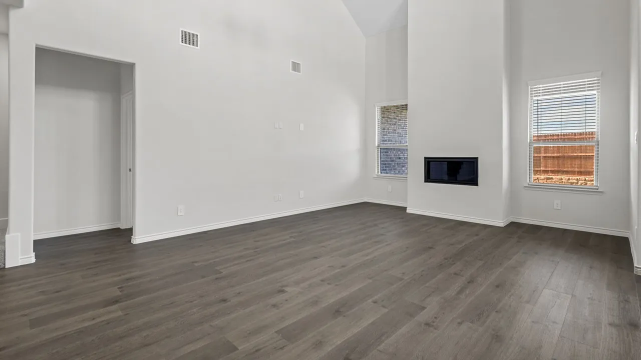 Vaulted ceilings, wood-finish flooring, recessed fireplace, and multiple windows