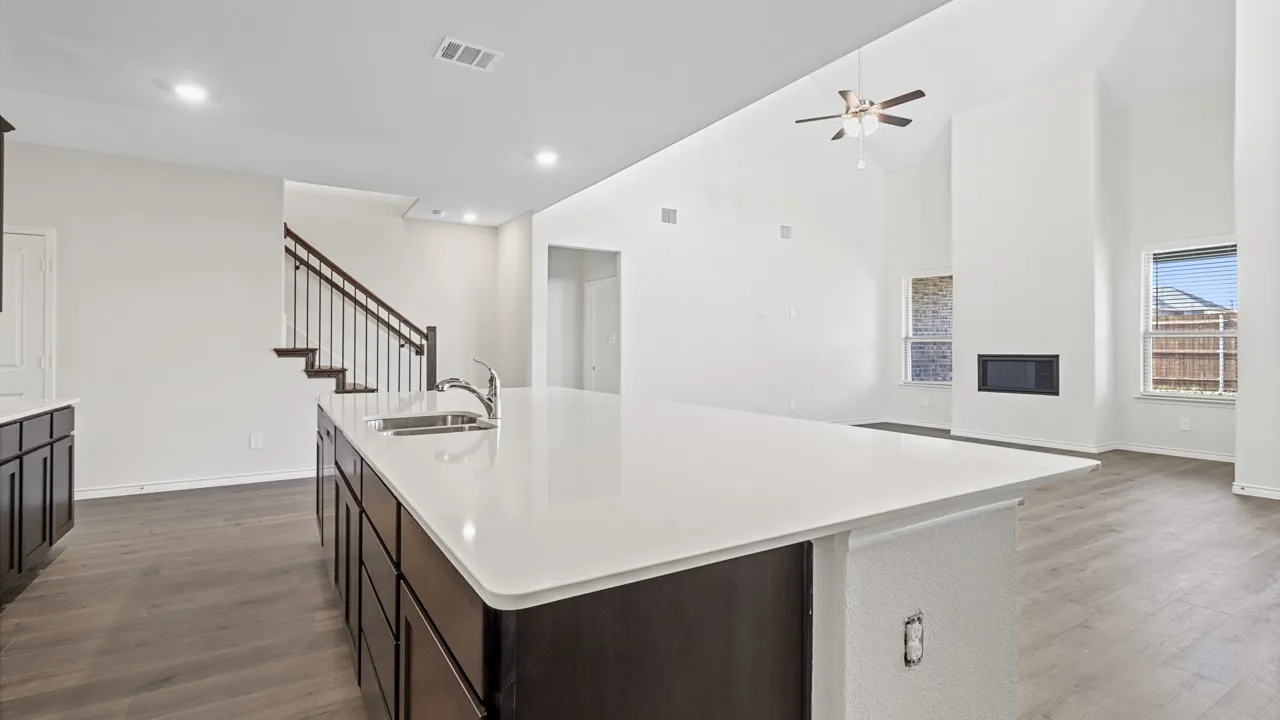 Kitchen island with an undermount sink and dark wood-finish cabinetry