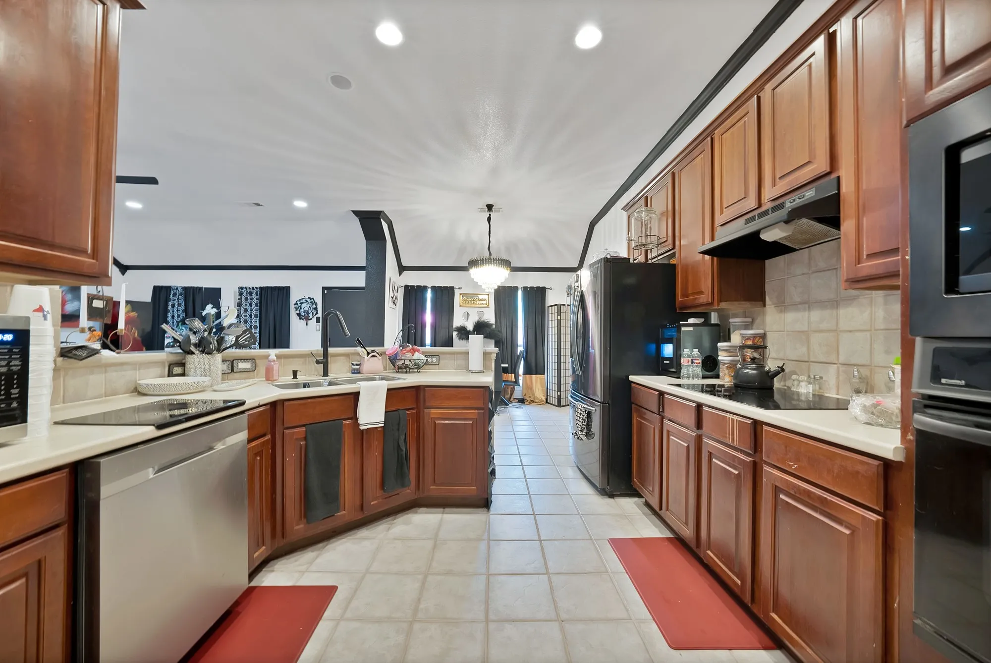 Kitchen featuring wood cabinetry, light-toned countertops, a tile backsplash, and recessed lighting