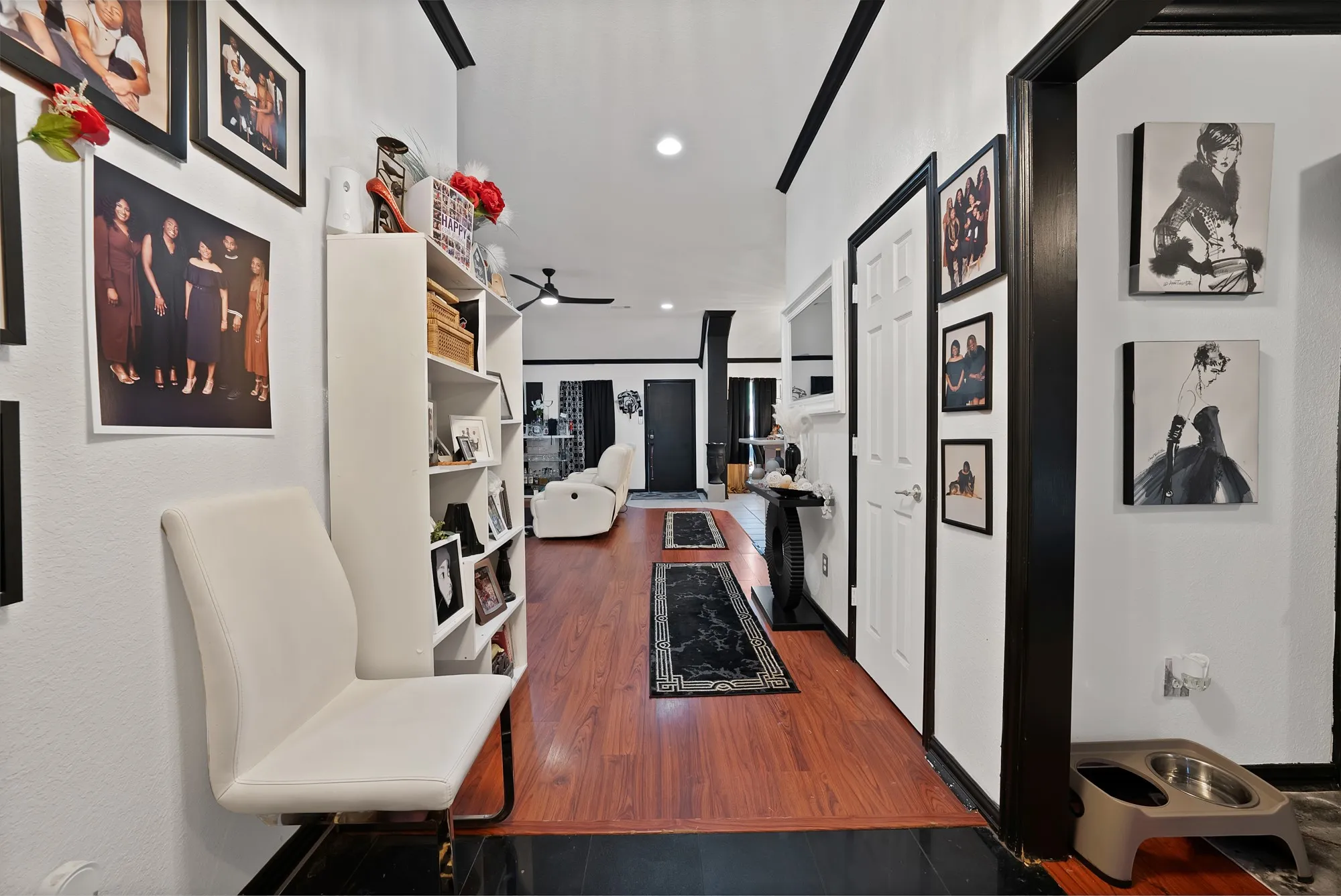 Hallway featuring wood-finish flooring, white walls, and dark trim