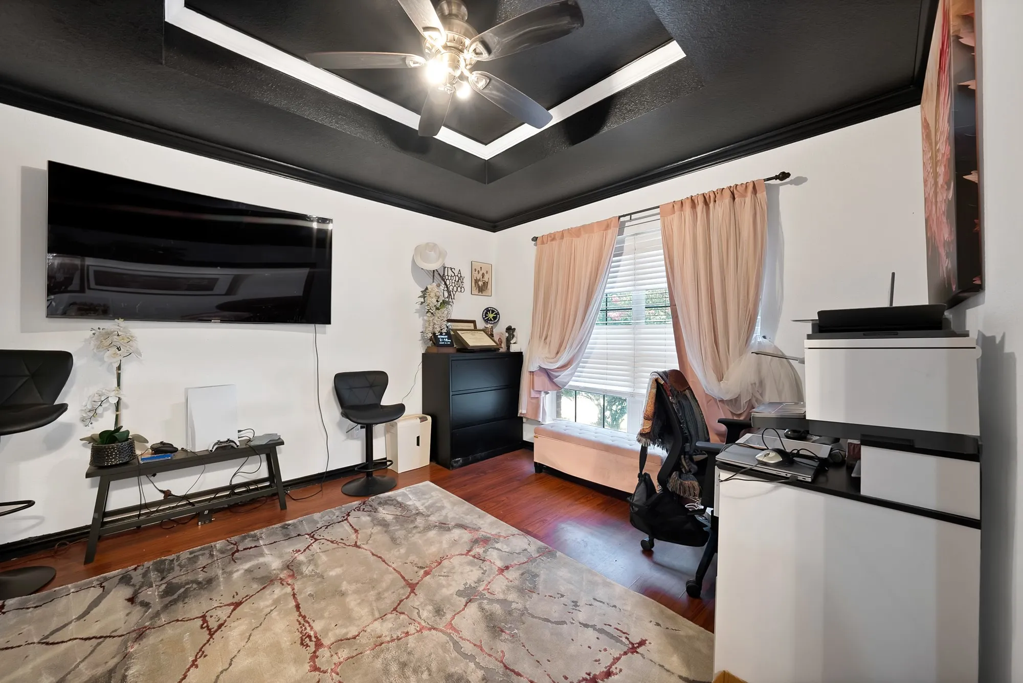 Tray ceiling with recessed lighting and ceiling fan, wood-finish flooring, white walls, and window with blinds