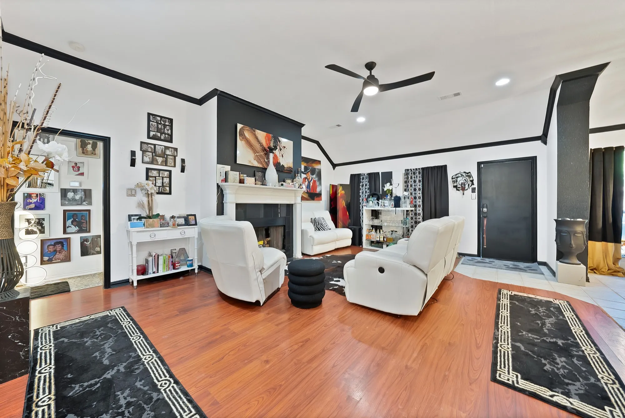 Wood-finish flooring, vaulted ceilings, ceiling fan, and a fireplace with a mantel
