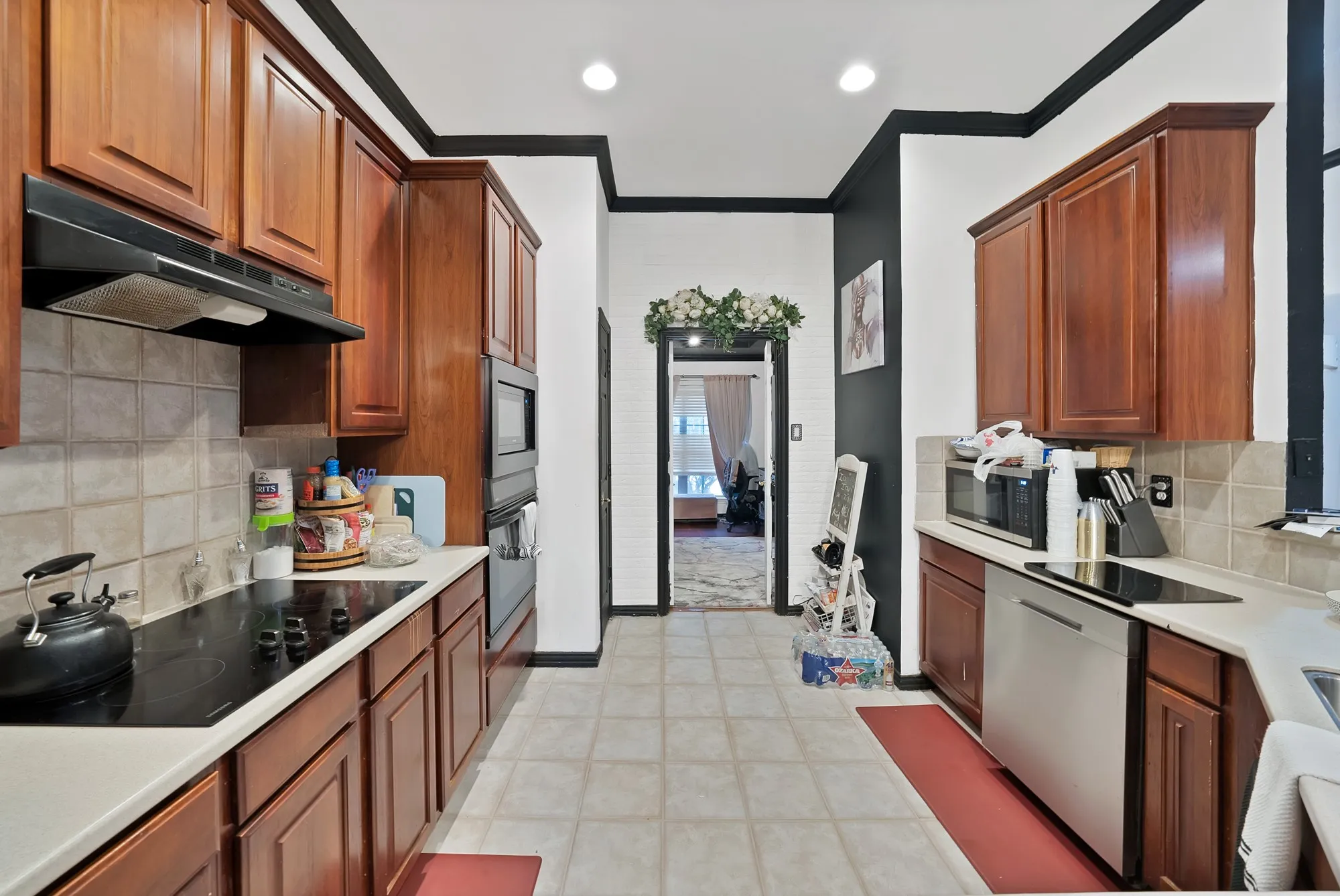 Kitchen featuring wood-finish cabinetry, integrated wall oven, built-in microwave, and a flat-top electric range