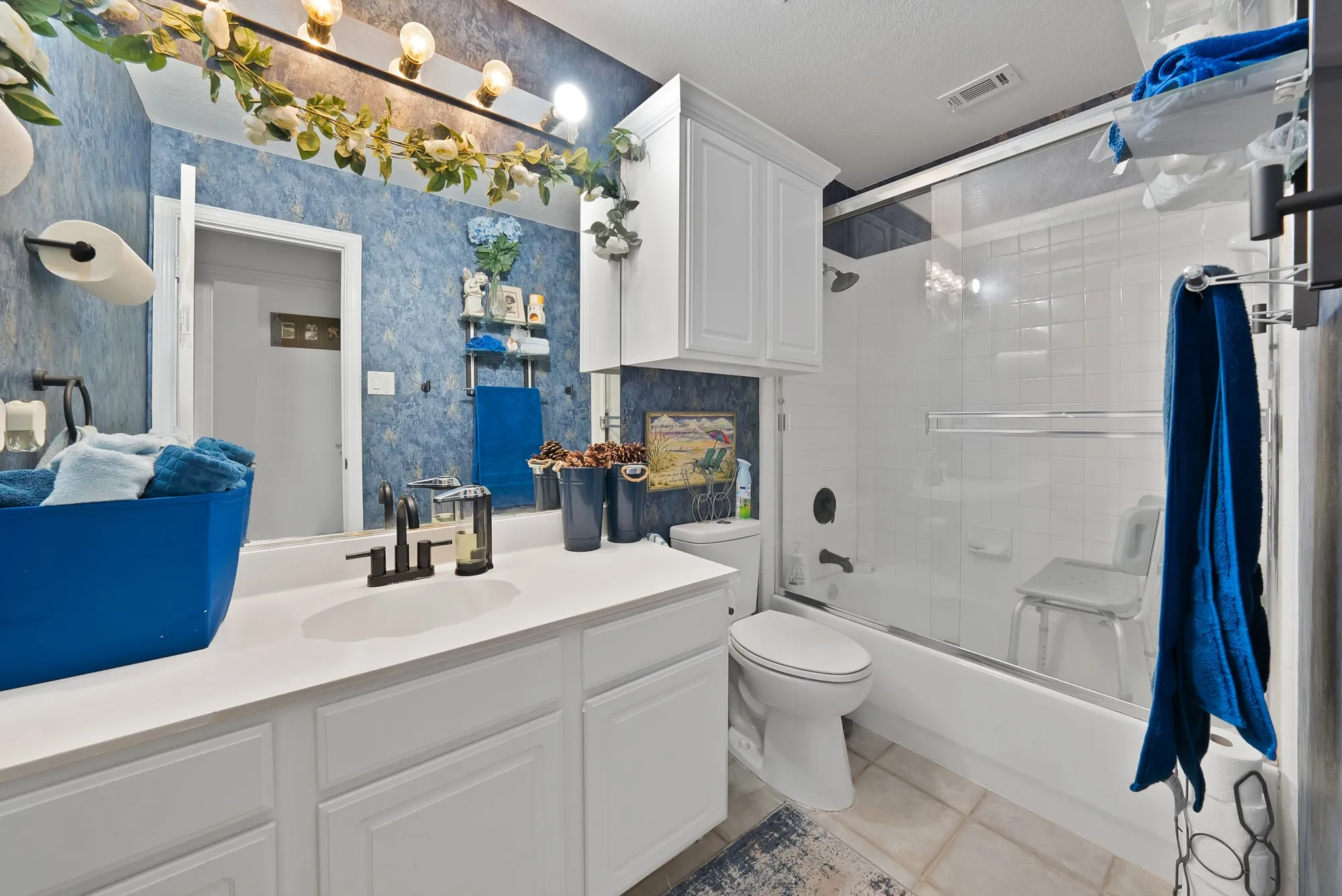 White vanity with integrated sink, matte black faucet, and white cabinetry