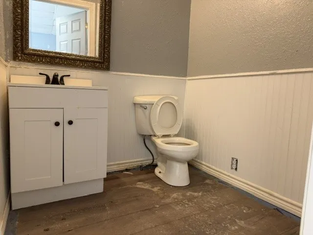 White vanity with dark hardware, white countertop, and dark-finish faucet