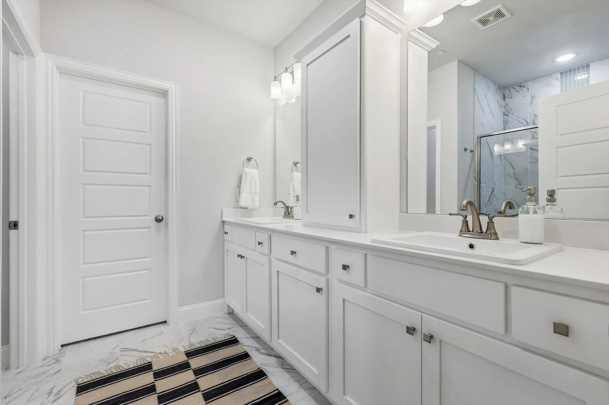 Primary bathroom featuring walk-in closet, water closet and two vanities