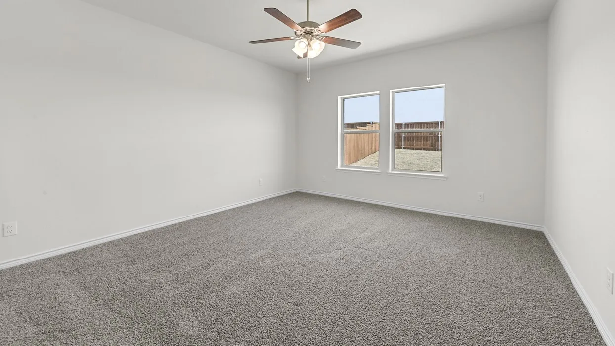 Spacious room featuring neutral carpet, white walls, two windows, and a ceiling fan with integrated lighting