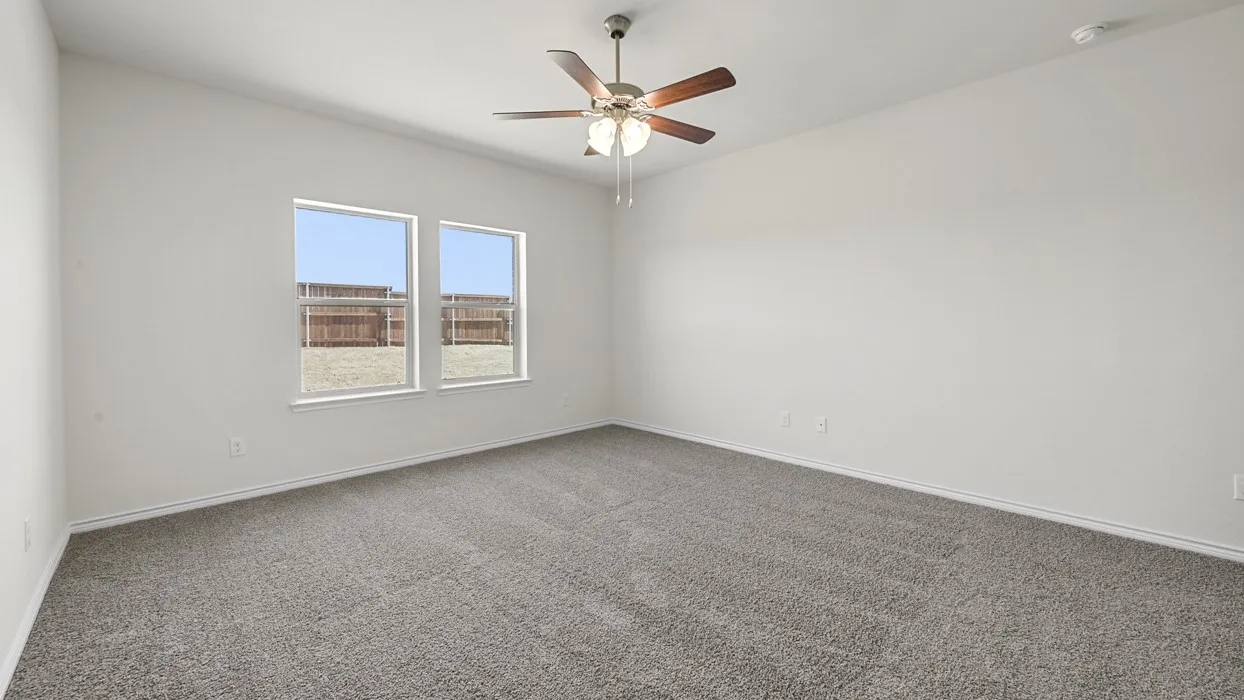 Neutral tone walls, ceiling fan with light fixture, and carpeted flooring
