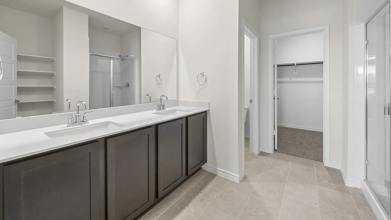 Dual vanity with white countertops, dark cabinetry, and chrome fixtures