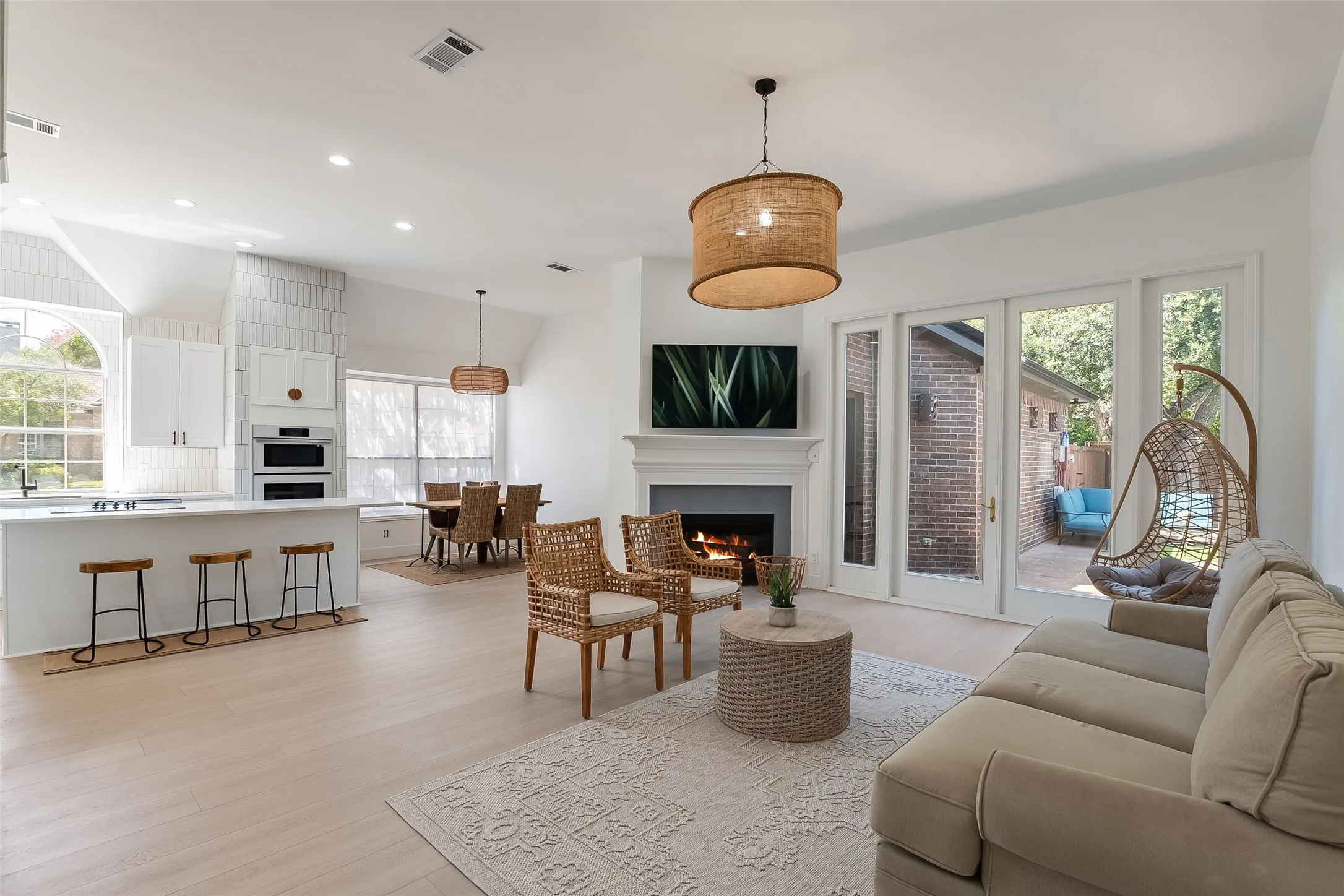 Open-concept living space featuring wood-finish flooring, a fireplace with a mantel, and sliding glass doors
