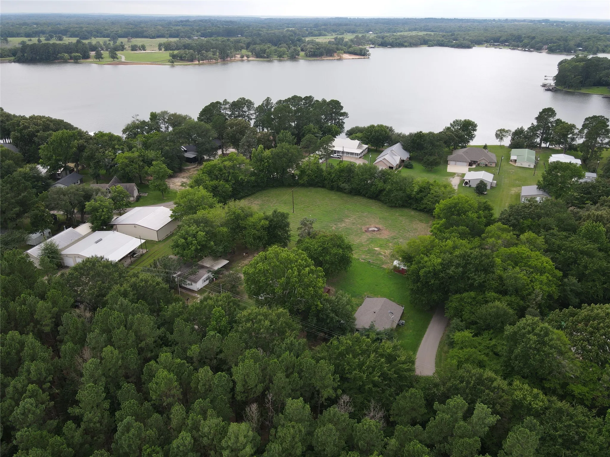Wooded property with a cleared building site and a gravel driveway