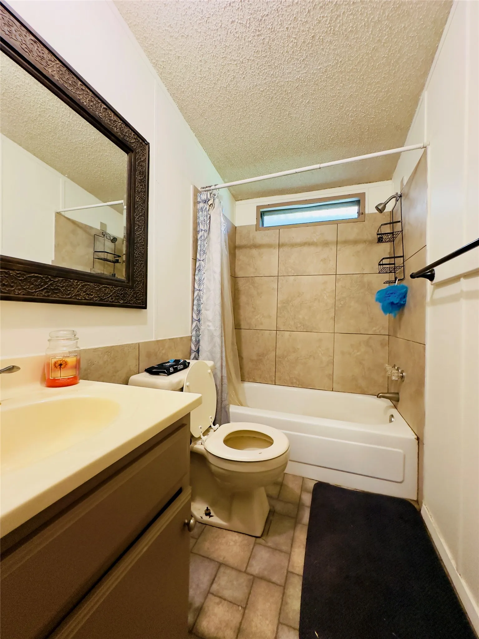 Bathroom featuring a vanity with integrated sink, a toilet, and a bathtub with tile surround