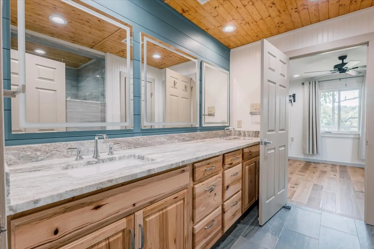 Jack-and-Jill bathroom featuring three lighted mirrors
