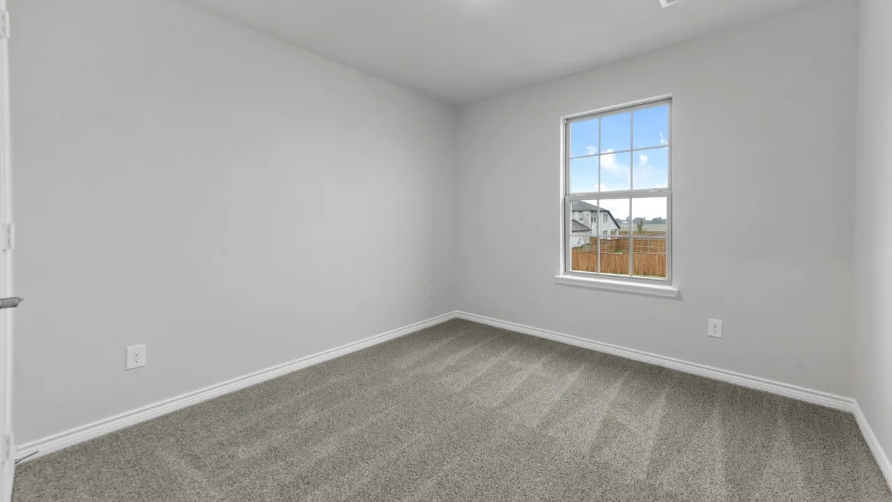 Neutral wall paint, carpeted flooring, and a single pane window