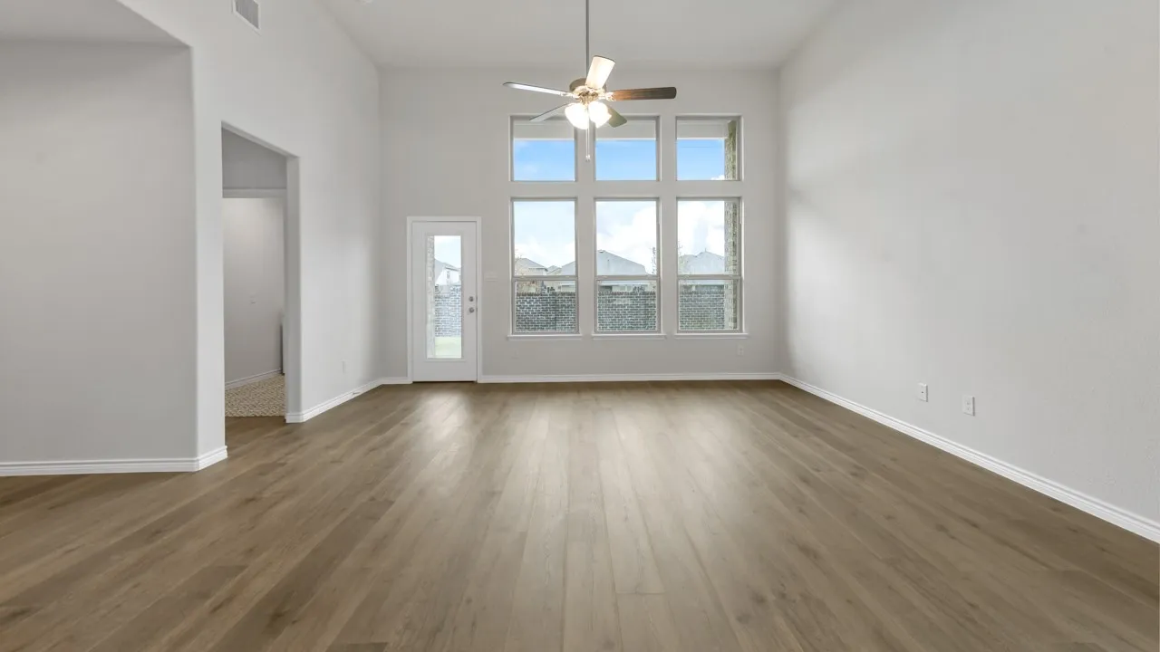 Vaulted ceiling with a ceiling fan, wood-finish flooring, and expansive windows