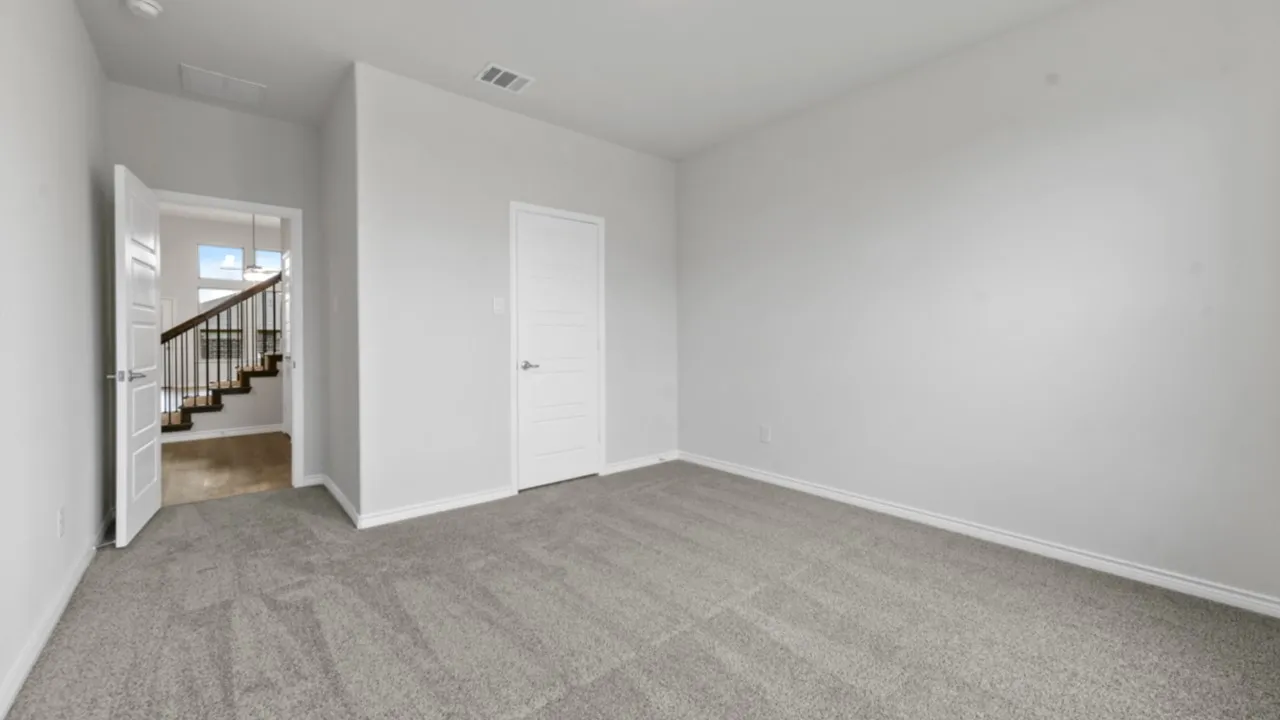 Plush gray carpeting, white painted walls, and a white interior door with contemporary hardware