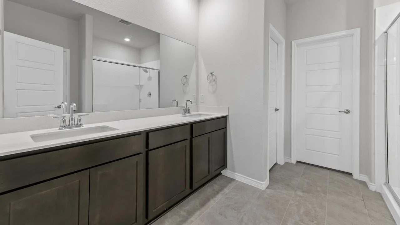 Dual vanity with undermount sinks, chrome fixtures, and dark wood-finish cabinetry