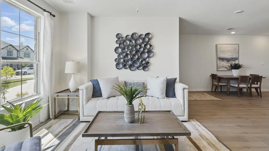 Bright living space with large window, wood-finish flooring, and a recessed lighting