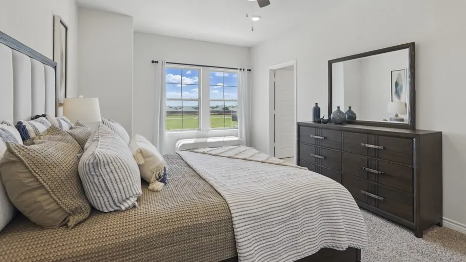Expansive window with a deep sill, neutral carpeting, light ceiling fan, and white paneled interior door