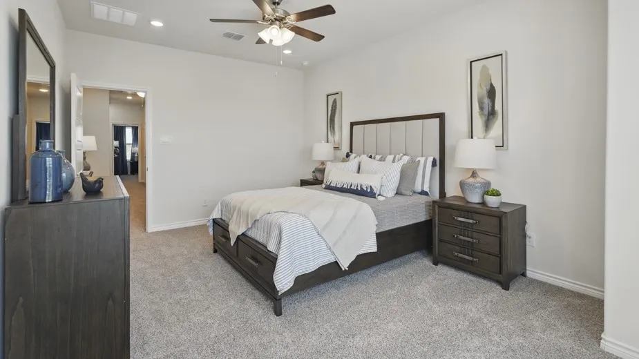 Soft gray carpeting, recessed lighting, and a ceiling fan create a comfortable atmosphere