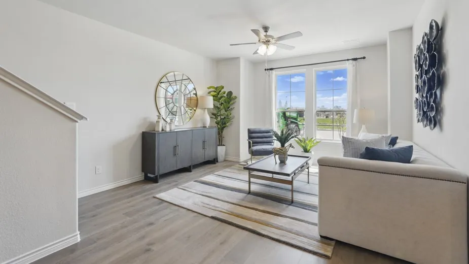 Wood-finish flooring throughout, bright white walls, and a ceiling fan with integrated lighting