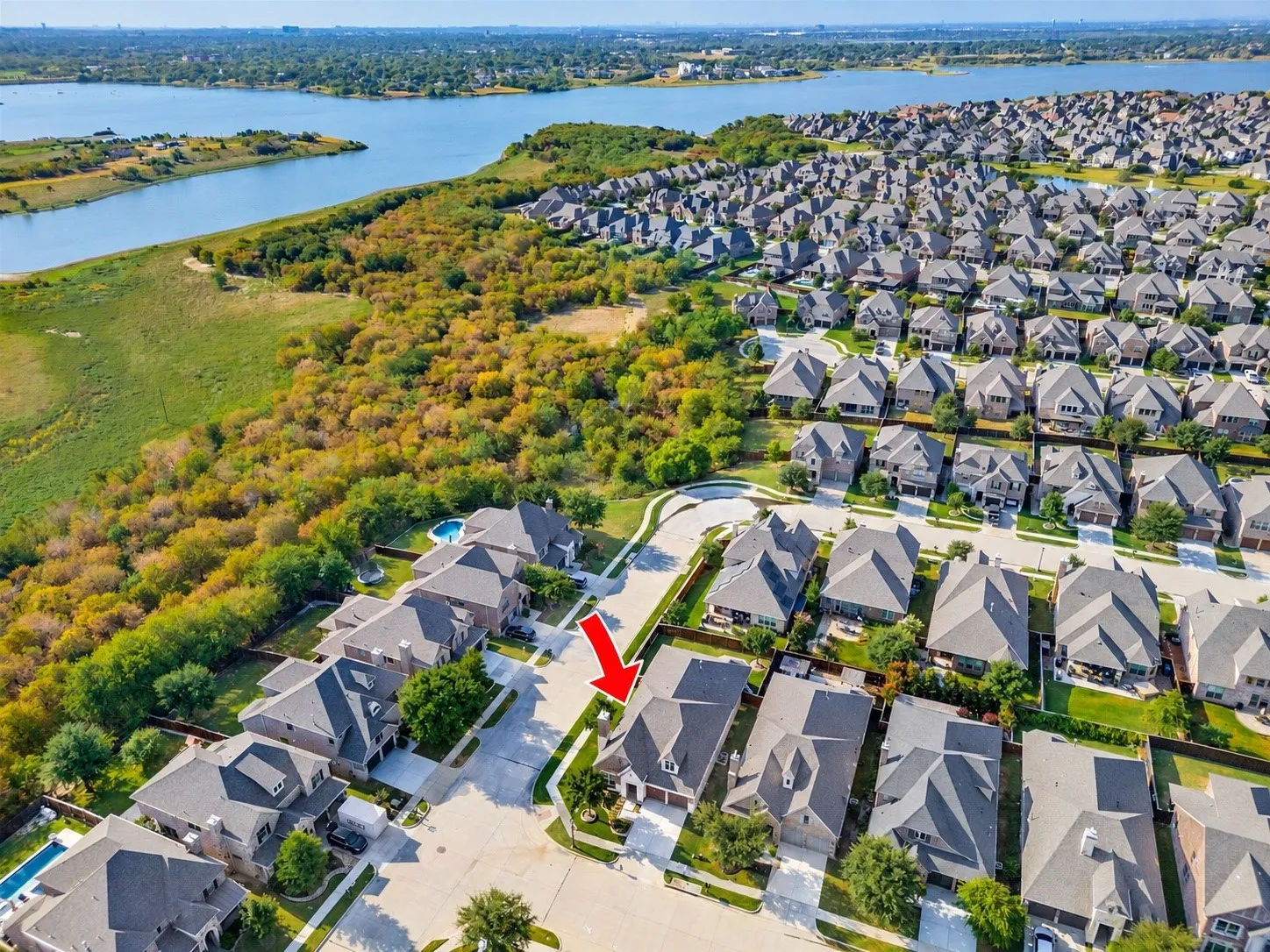 Aerial view highlights the home’s desirable corner-lot location, offering an expansive fenced backyard with plenty of green space and a covered patio. The generous yard provides endless possibilities for outdoor entertaining, play, pets, or creating your own backyard retreat.