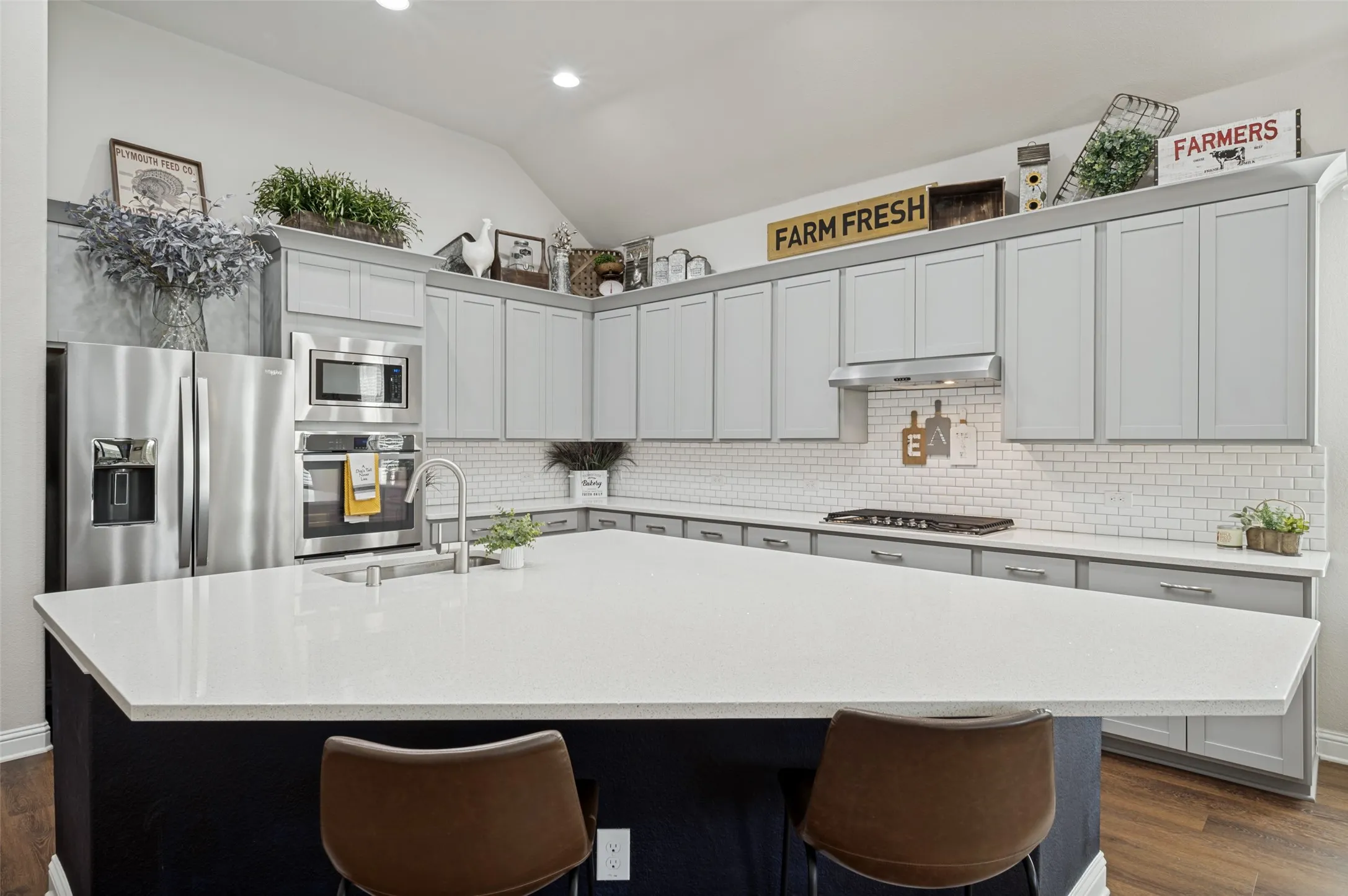 Beautiful kitchen featuring an oversized island with seating, abundant cabinetry, quartz countertops, subway tile backsplash, stainless steel appliances, gas cooktop, and plenty of prep and storage space.