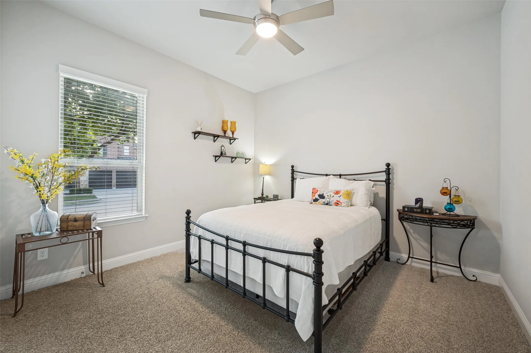 Spacious secondary bedroom featuring a vaulted ceiling, plush carpeting, ceiling fan, and a large window offering plenty of natural light.