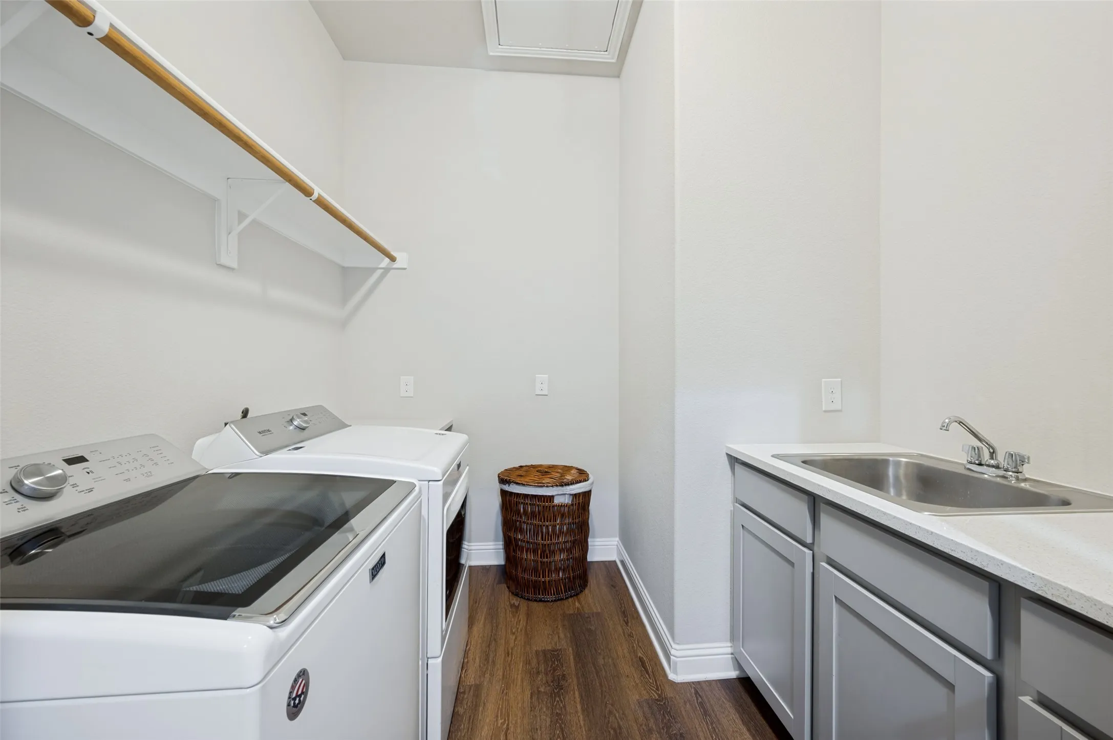 Spacious laundry room featuring a utility sink, built-in cabinetry, hanging space, and plenty of room for everyday organization.