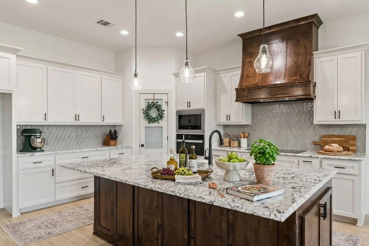 White shaker cabinetry paired with a wood-finish island, granite countertops, a diamond-patterned backsplash, and a custom wood-finish range hood
