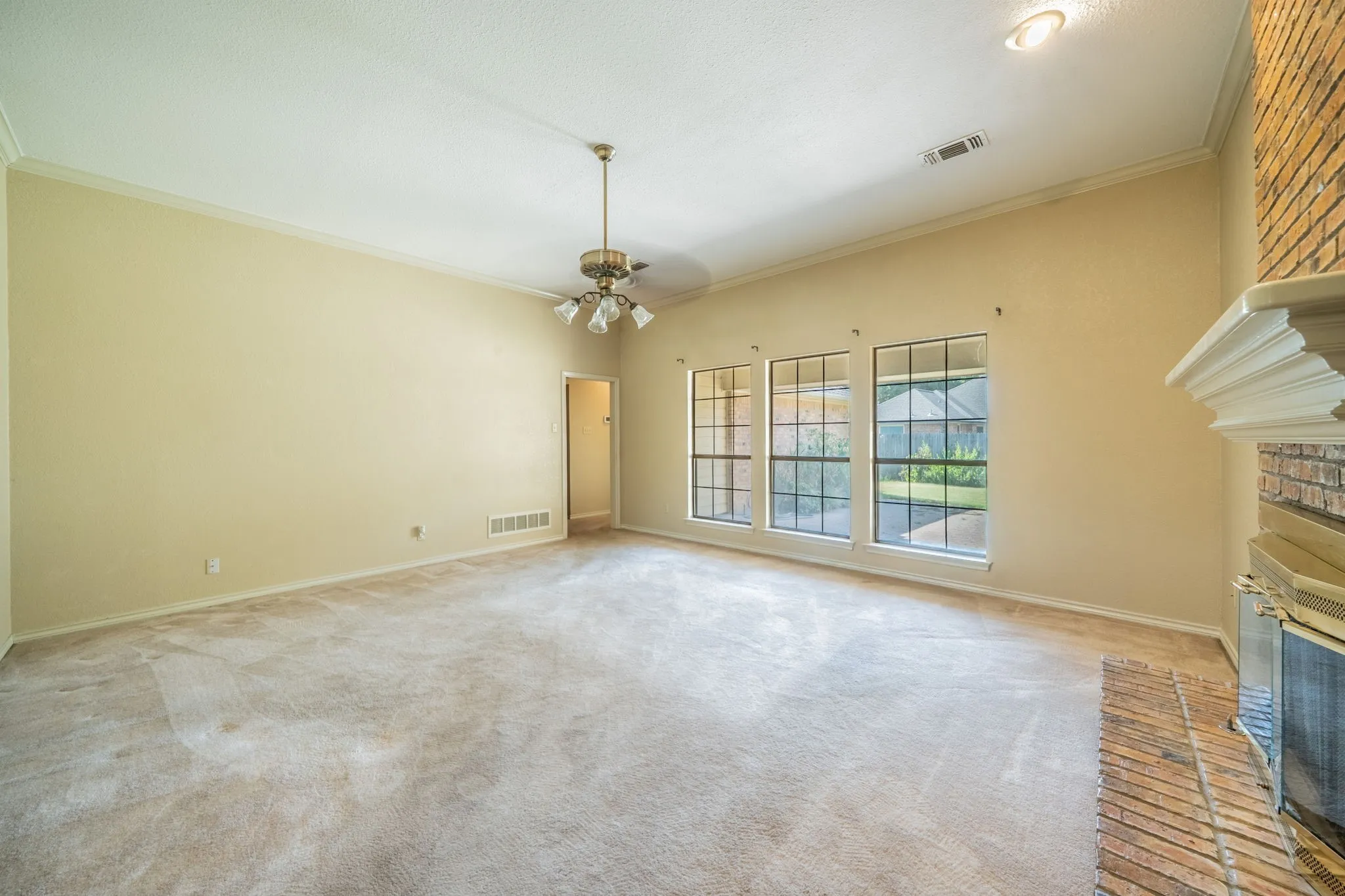Family room is spacious with a fireplace.  It overlooks the backyard with it's covered patio.