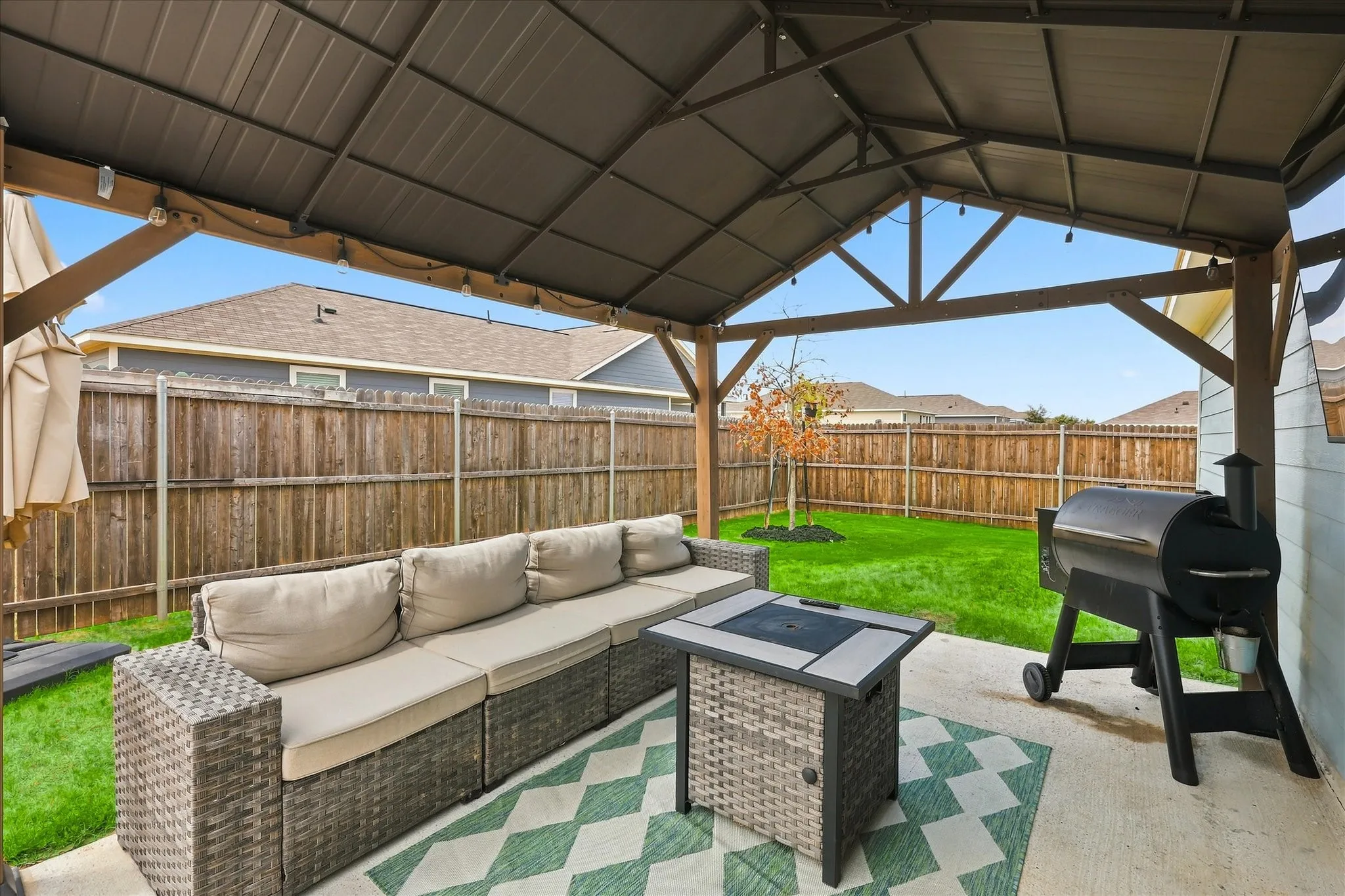 Covered patio featuring a concrete slab and string lighting