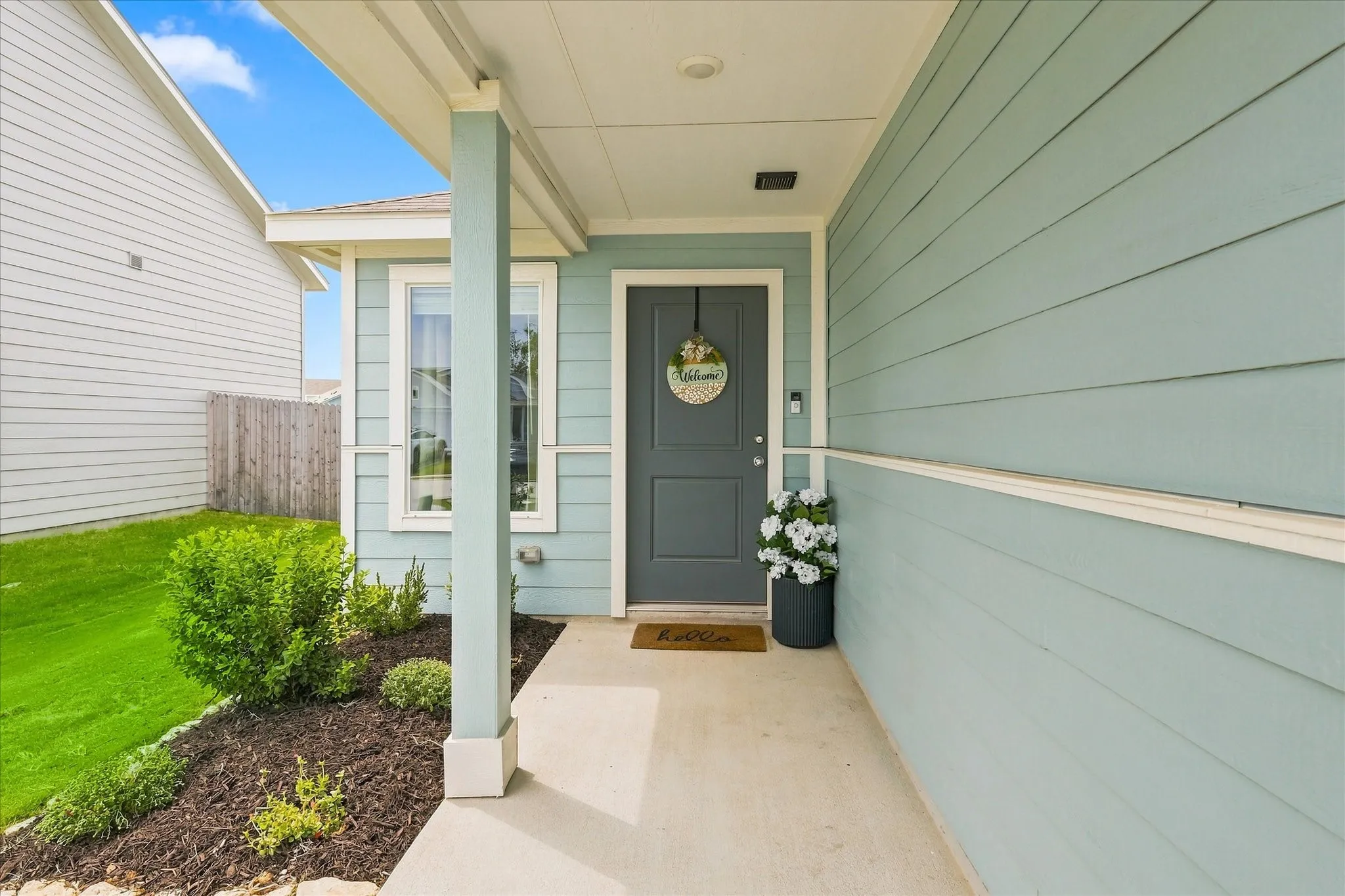Inviting covered front porch with light blue siding