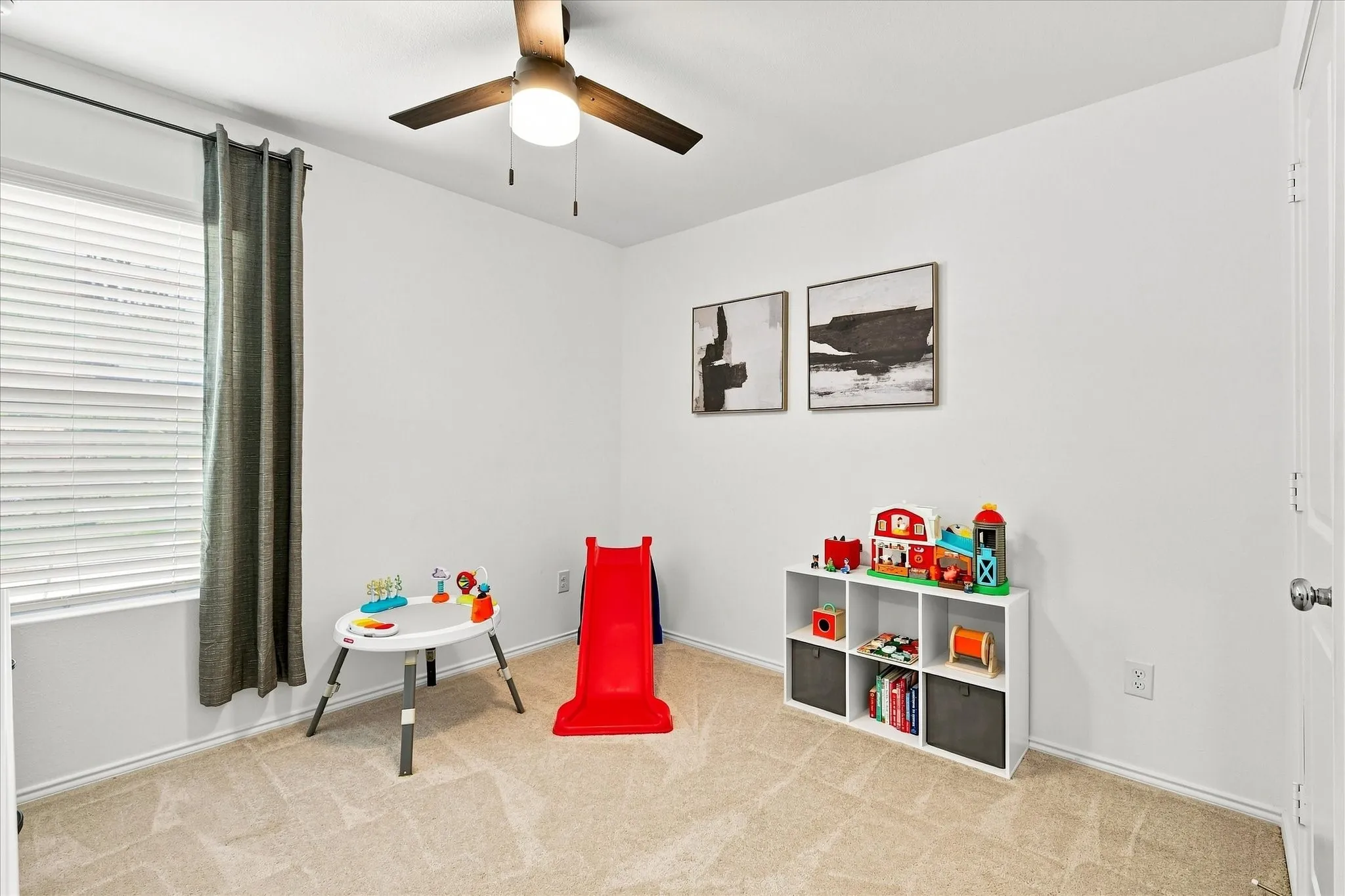 Neutral wall paint, ceiling fan with integrated lighting, window with blinds, and carpeted flooring