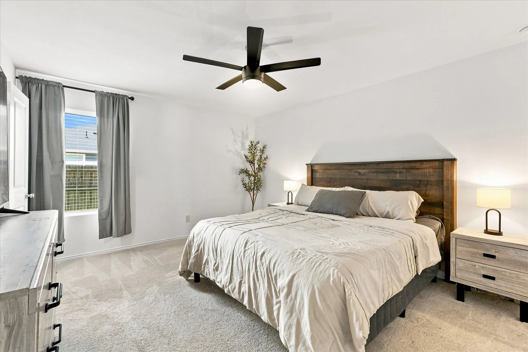 Carpeted flooring, a window with exterior visibility, and a ceiling fan with integrated lighting