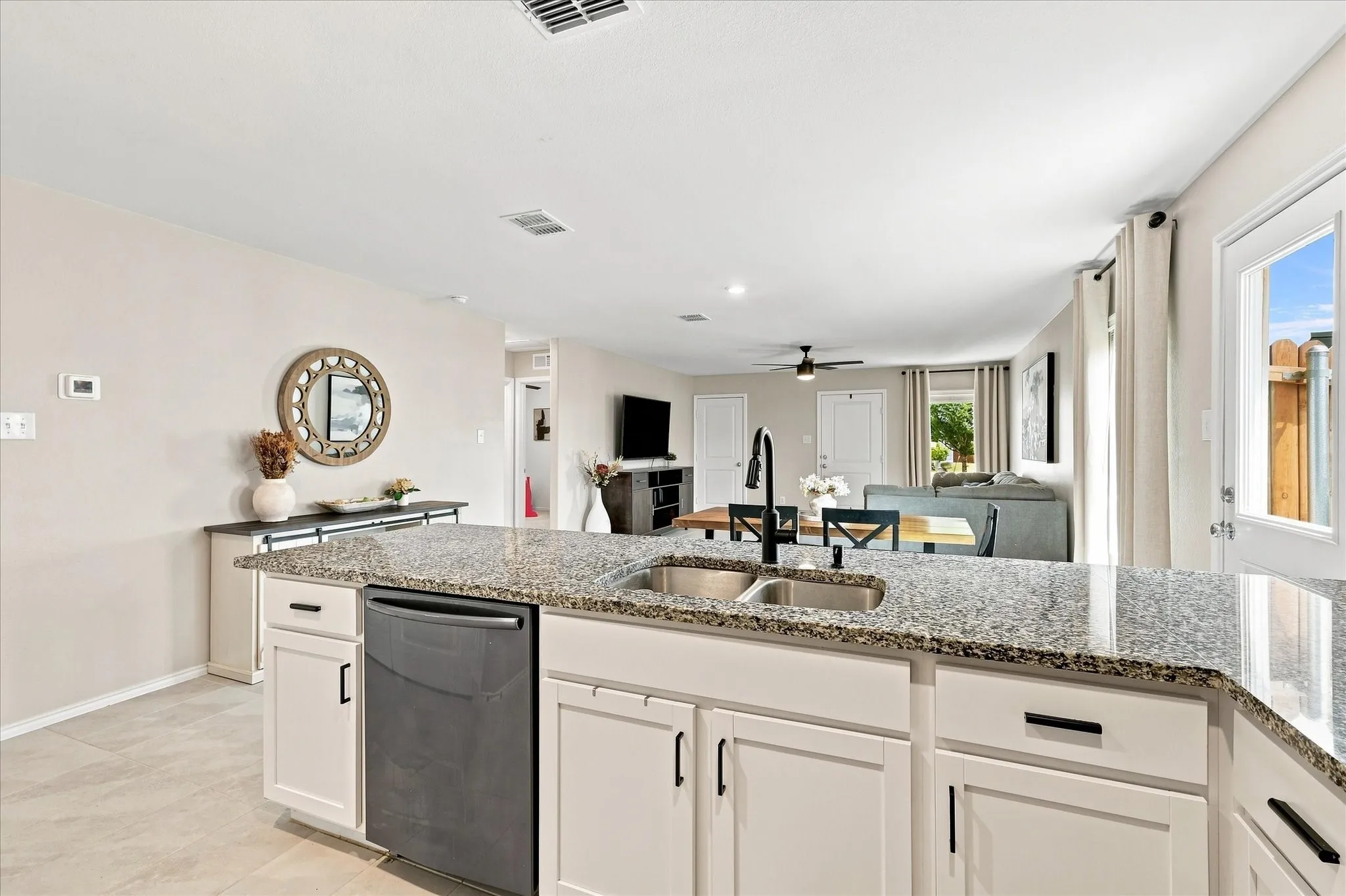Kitchen island with granite-finish countertop, undermount double-basin sink, and a matte black gooseneck faucet