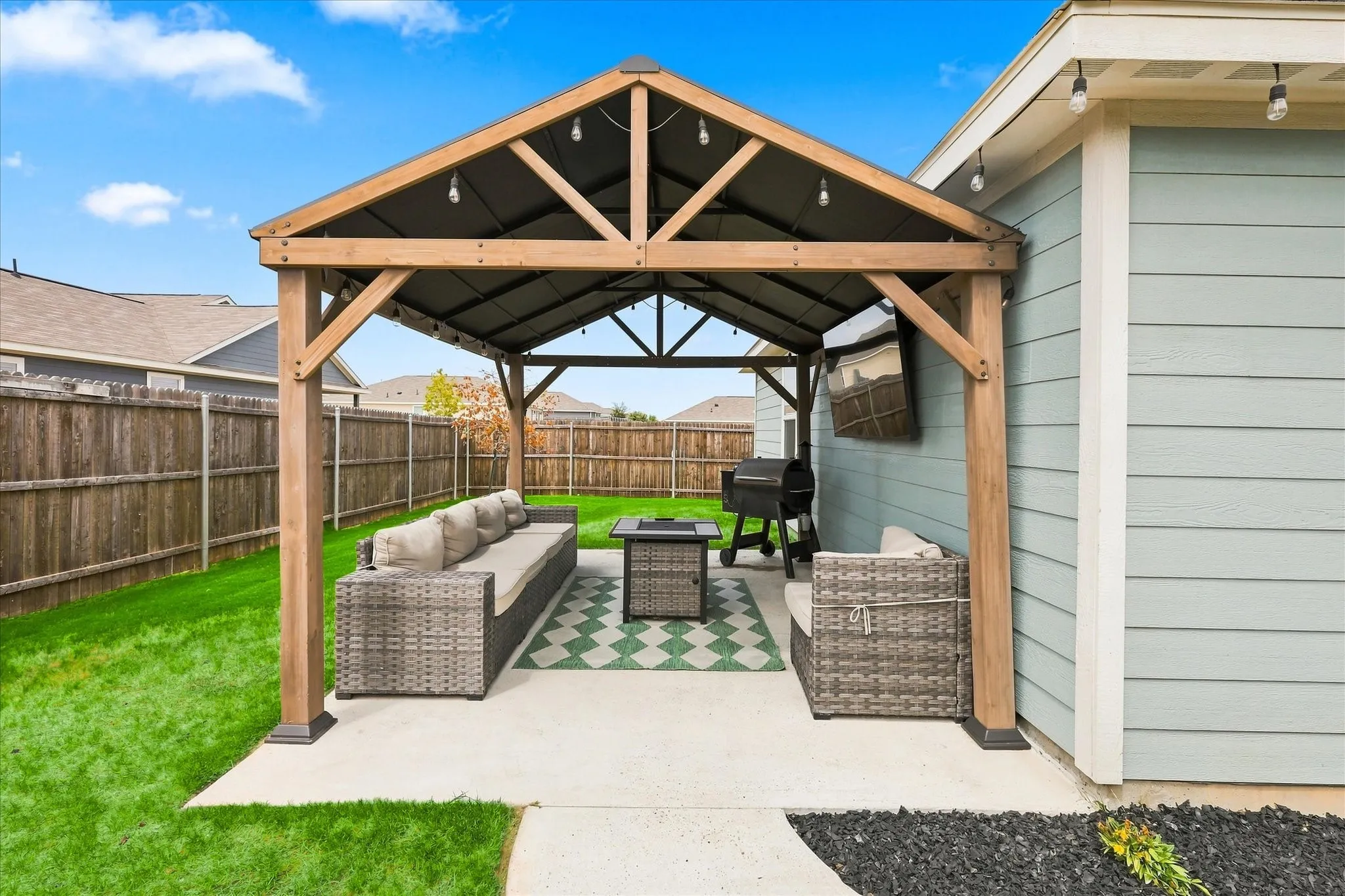 Covered patio featuring a wooden pergola and string lighting