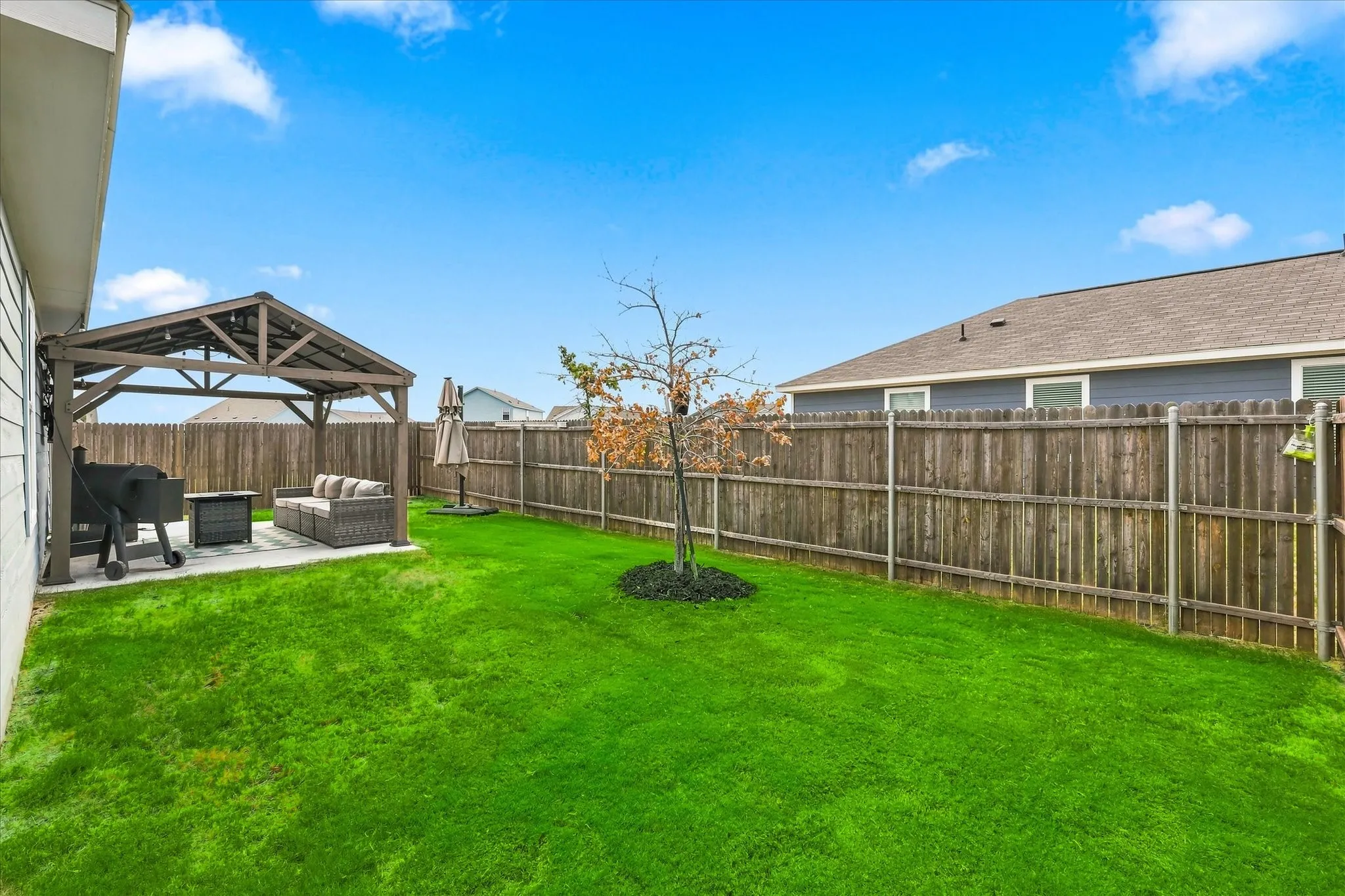 Expansive green lawn with a wooden privacy fence