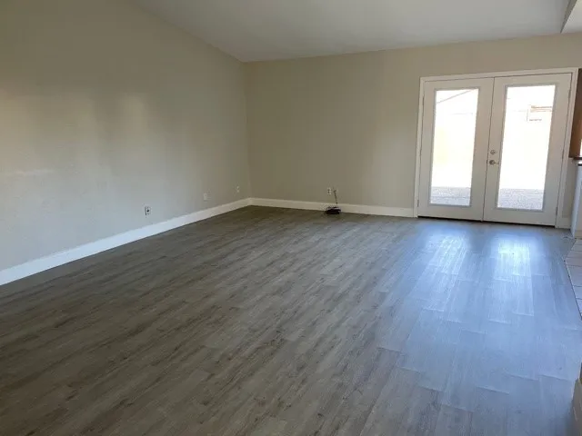 Wood-finish flooring with light-colored walls and white trim