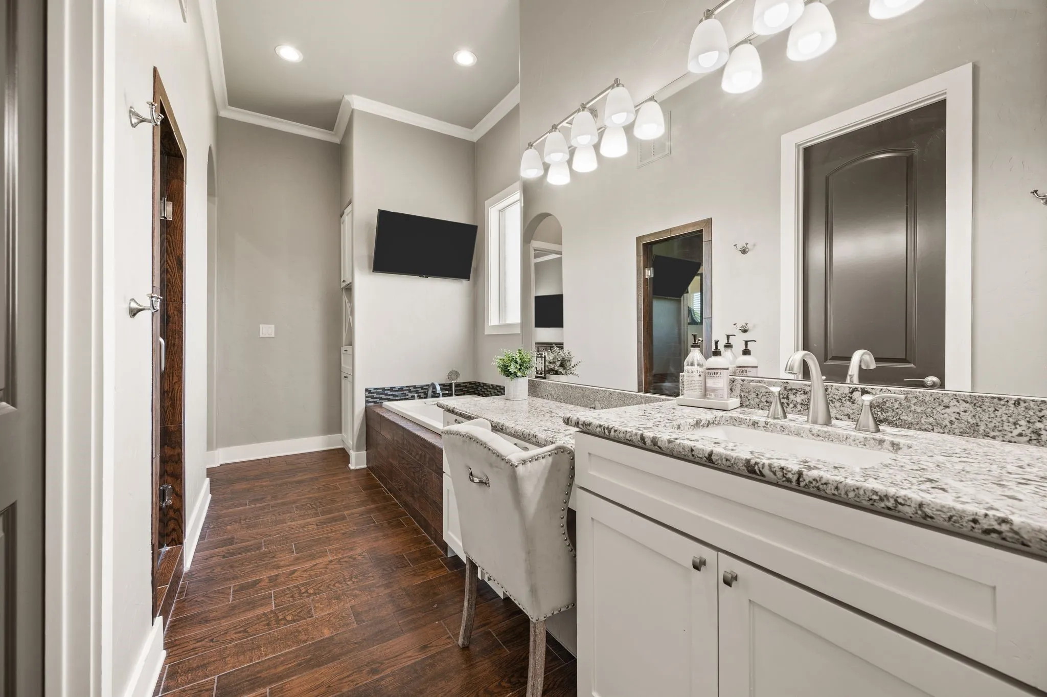 The luxurious primary bathroom features an extended granite vanity, abundant cabinetry, dedicated seated makeup space & a relaxing jetted soaking tub! His and her vanities and water closets!