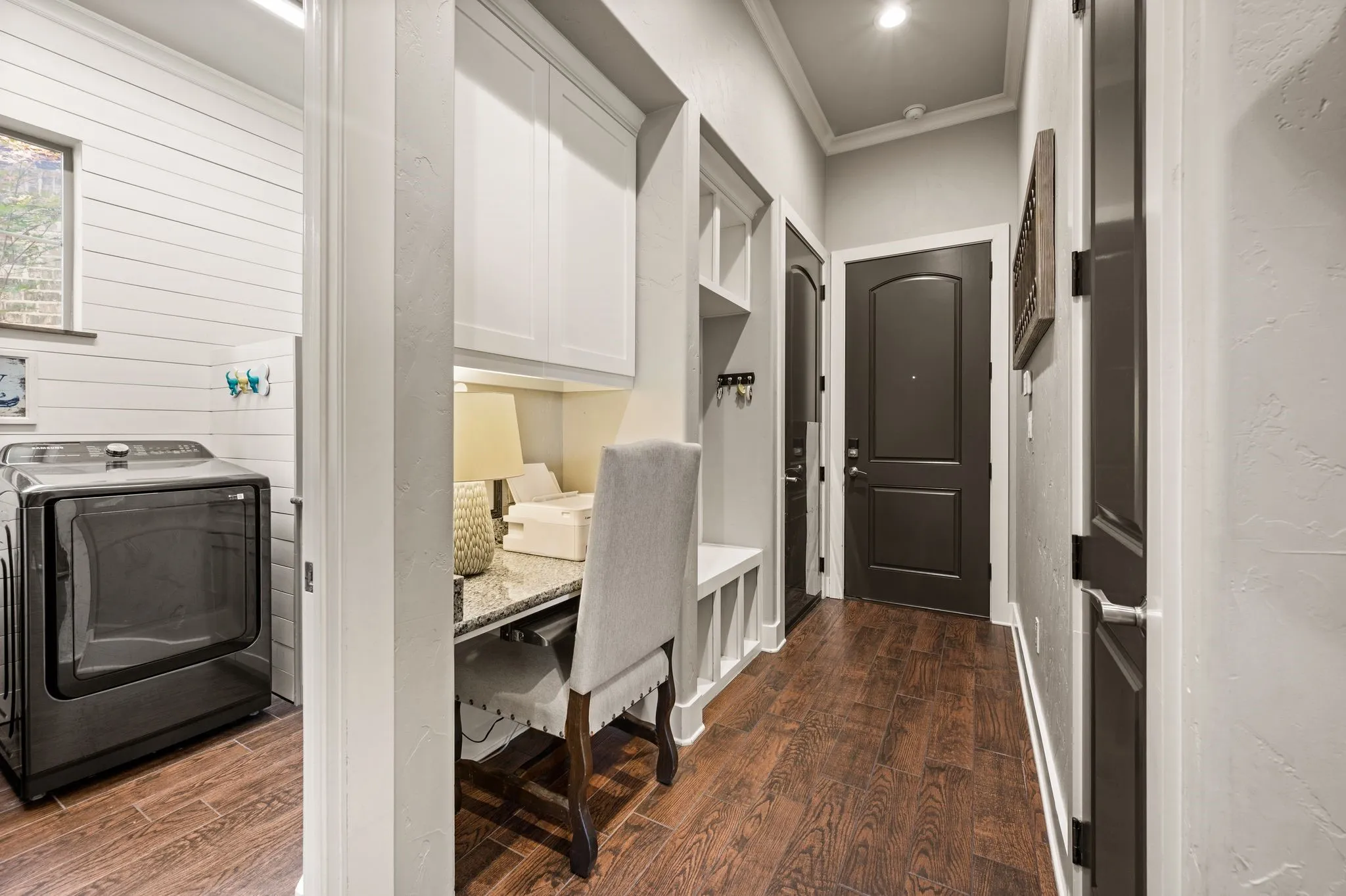 The functional mudroom includes built-in cabinetry, a desk or planning station, bench seating & easy access to the laundry room and garage.