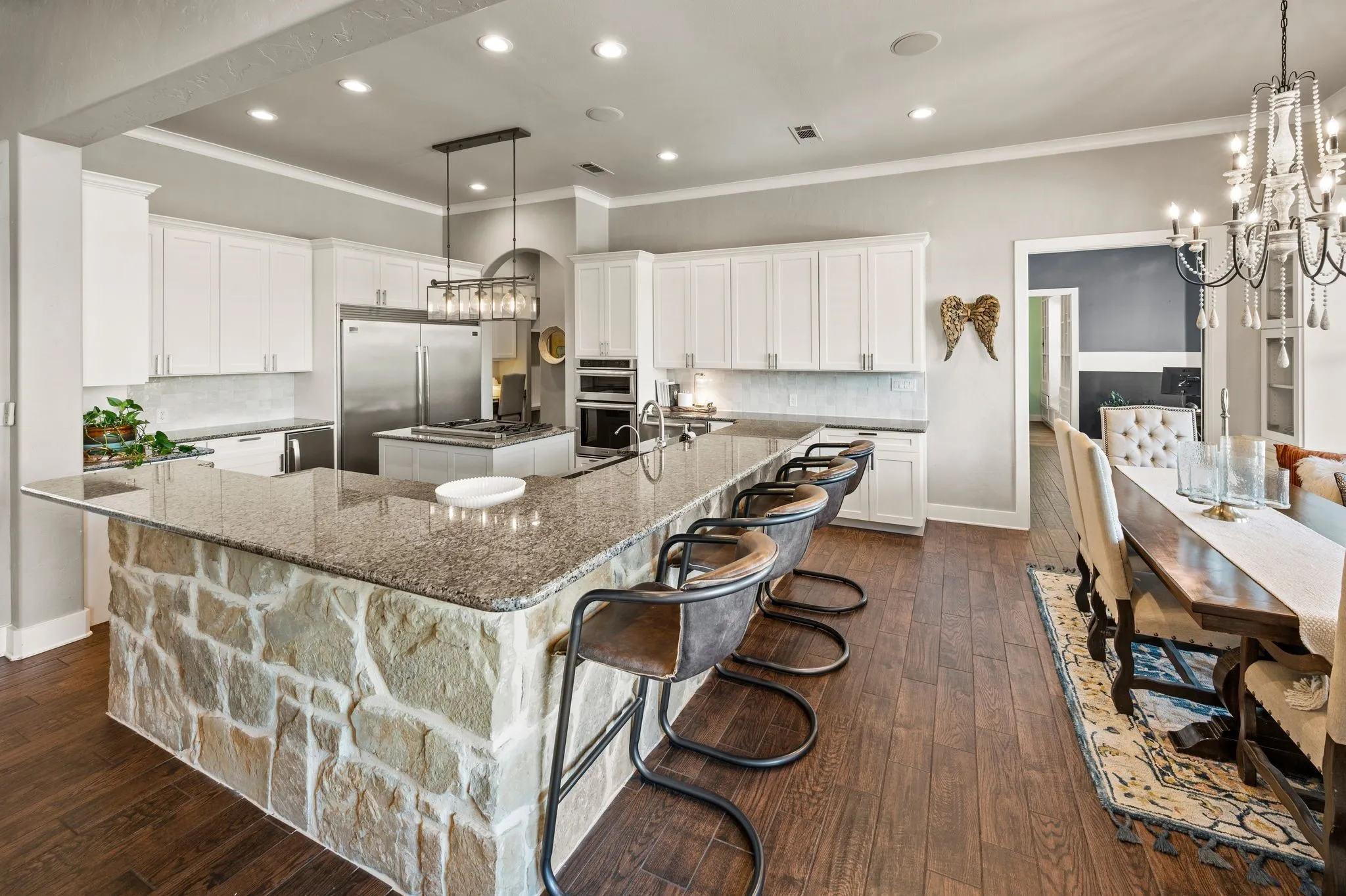 The spacious chef’s kitchen features extensive cabinetry, granite countertops, stainless steel appliances & an oversized stone-accented breakfast bar.